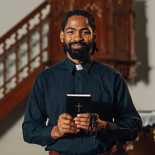 industry-religious a smiling priest holding the bible